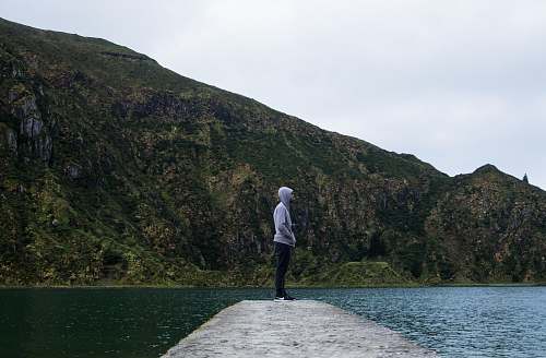 portugal man standing near body of water mountain